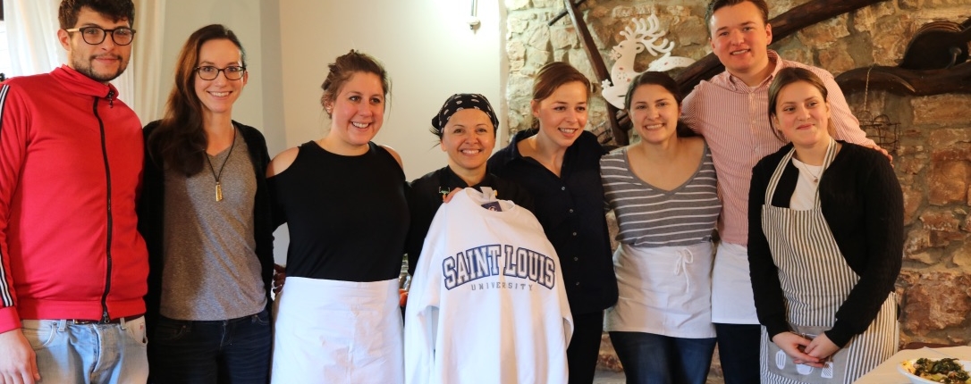 Ogliastro cilento Group picture St.Louis University students with Donatella showing her St.Louis university sweater in the farm dining room